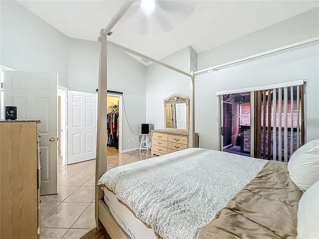 a spacious bedroom with a bed and a refrigerator