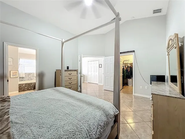 a large bedroom with a bed and a view of living room
