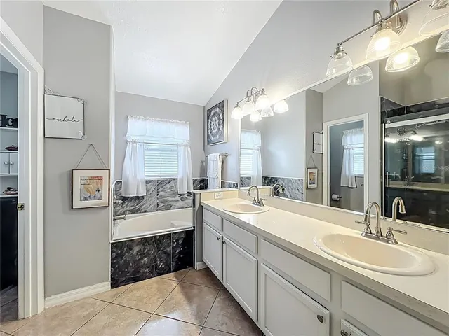 a large bathroom with a double vanity sink mirror and bathtub