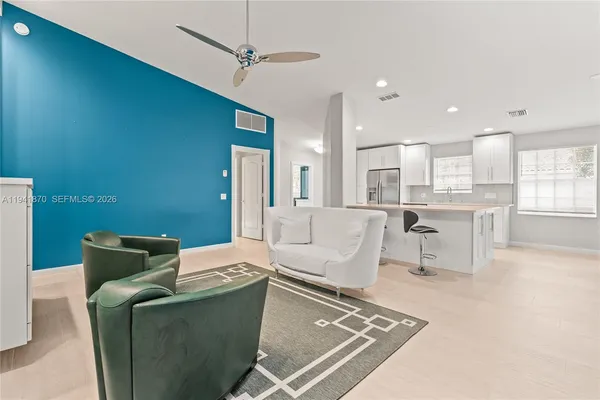 a living room with furniture and kitchen view
