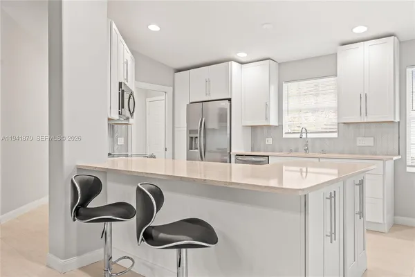 a kitchen with stainless steel appliances granite countertop a sink and a refrigerator