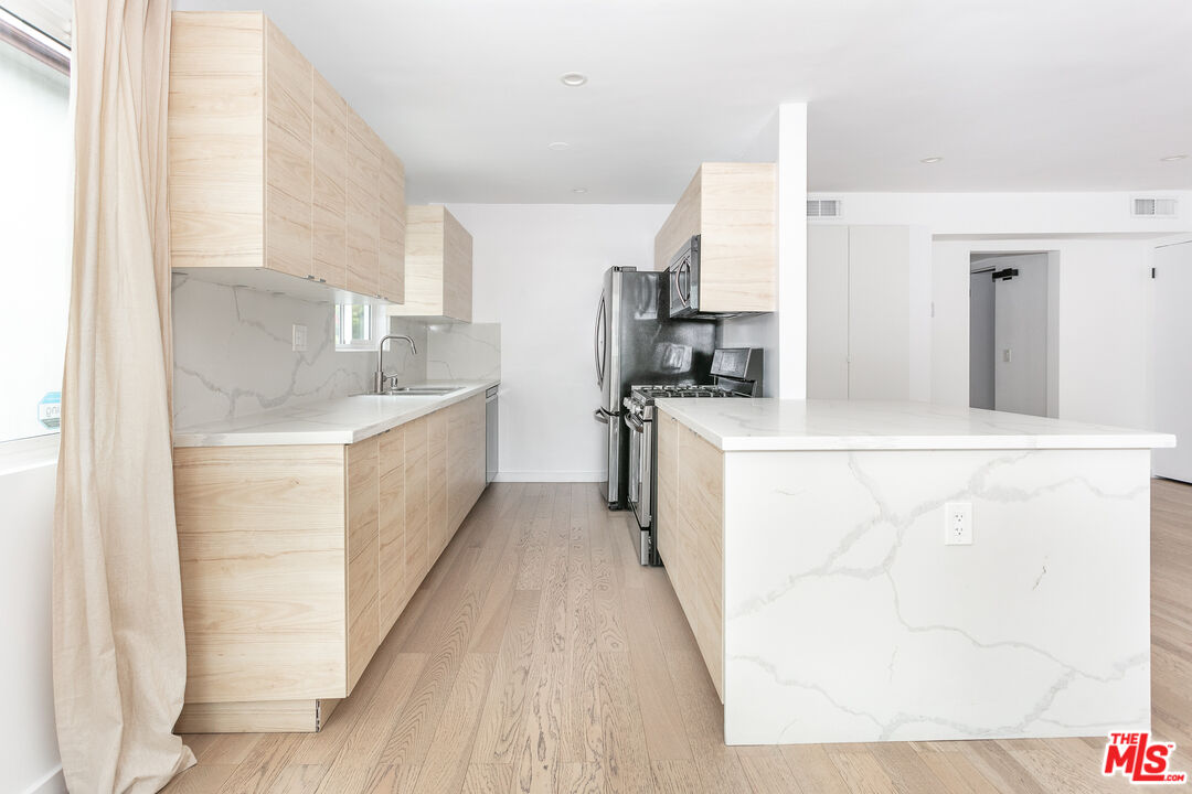 560 Kings Road, Unit 4 Los Angeles, CA 90048 - Photo 3 of 10 a large white kitchen with cabinets