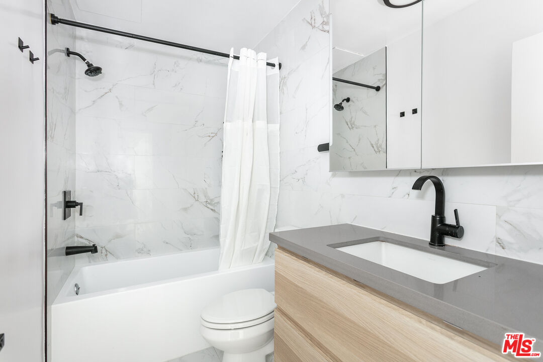 560 Kings Road, Unit 4 Los Angeles, CA 90048 - Photo 6 of 10 a bathroom with a bathtub shower sink vanity and toilet