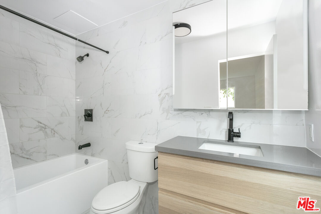 560 Kings Road, Unit 4 Los Angeles, CA 90048 - Photo 8 of 10 a bathroom with a sink a toilet and bathtub