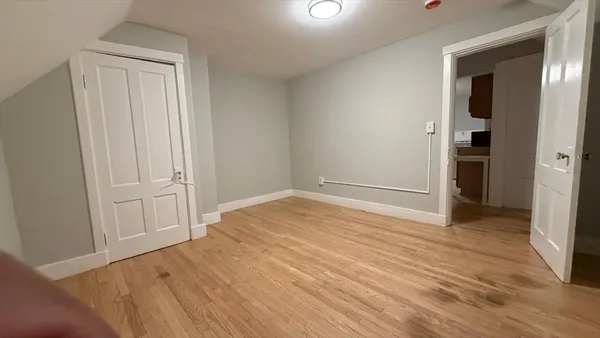 a view of empty room with wooden floor