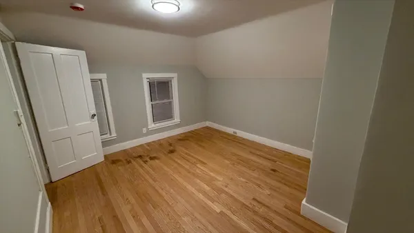 an empty room with wooden floor and cabinet