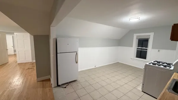 a view of kitchen with furniture and refrigerator