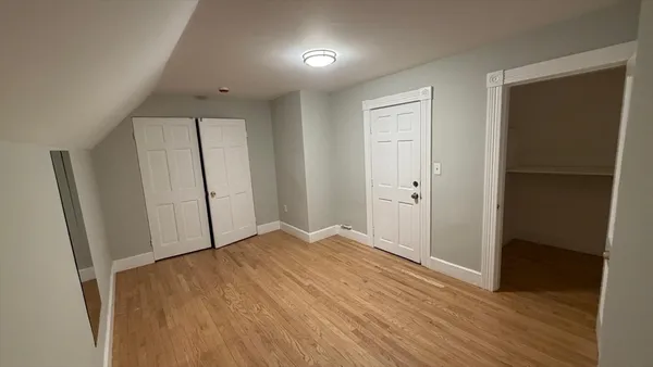 an empty room with wooden floor and closet