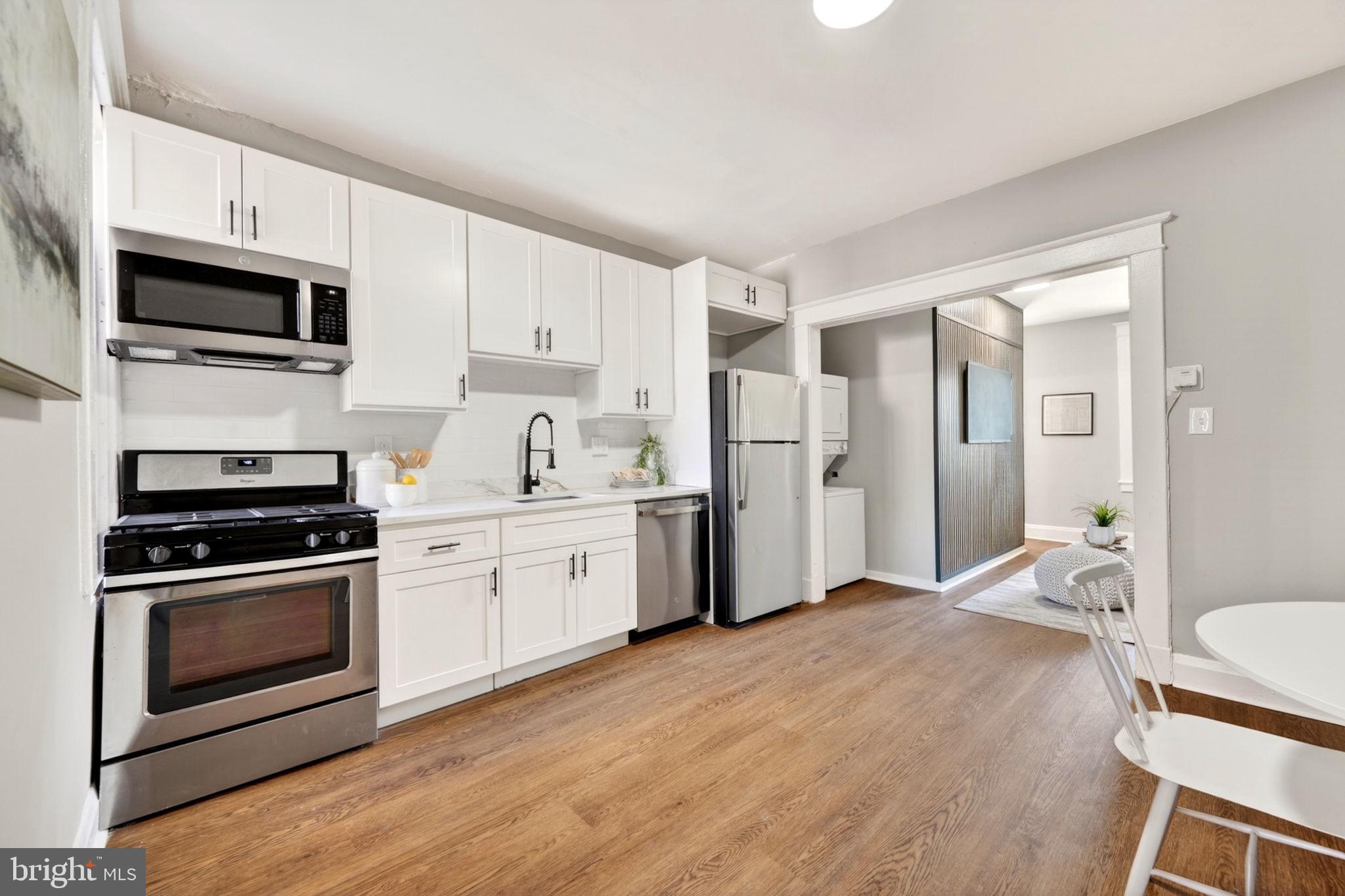 1358 Homestead Street Baltimore, MD 21218 - Photo 11 of 35 a kitchen with stainless steel appliances a stove a sink cabinets and a refrigerator
