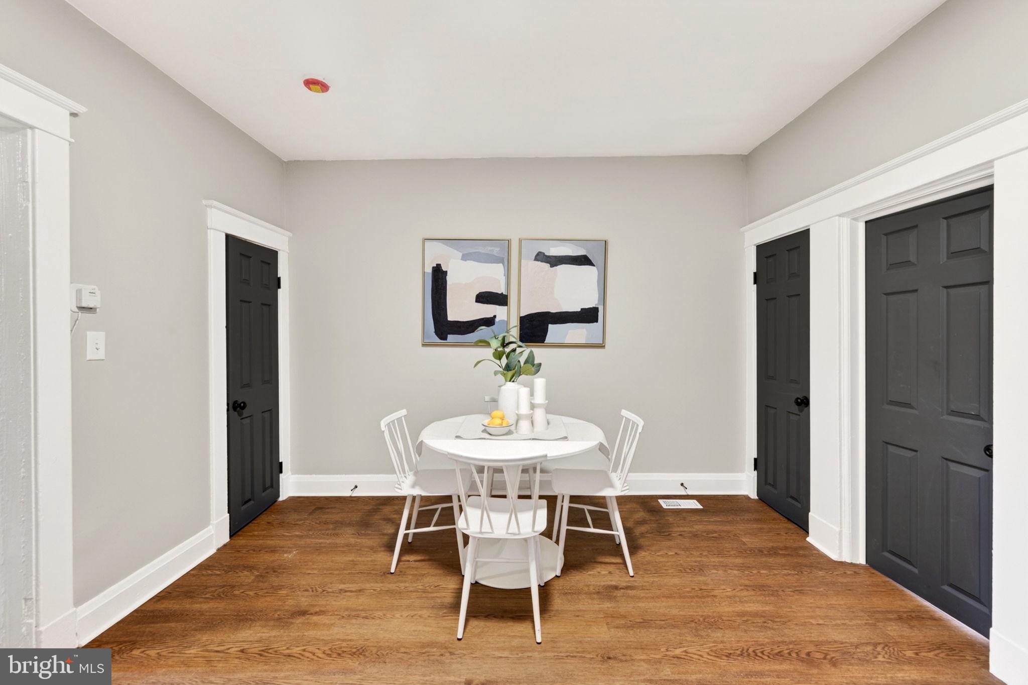 1358 Homestead Street Baltimore, MD 21218 - Photo 16 of 35 a dining room with wooden floor a chandelier a wooden table and chairs
