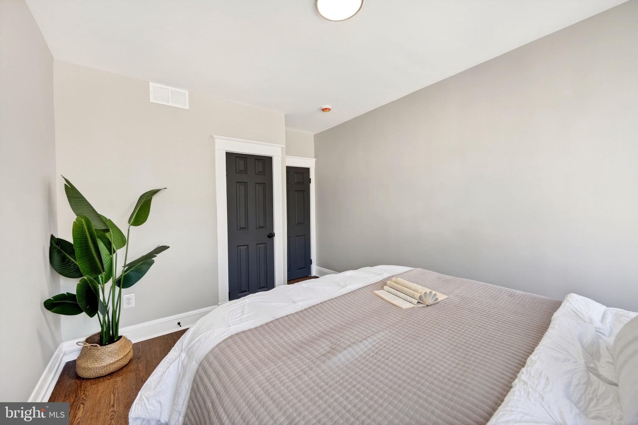 1358 Homestead Street Baltimore, MD 21218 - Photo 27 of 35 a bedroom with a large bed and potted plant