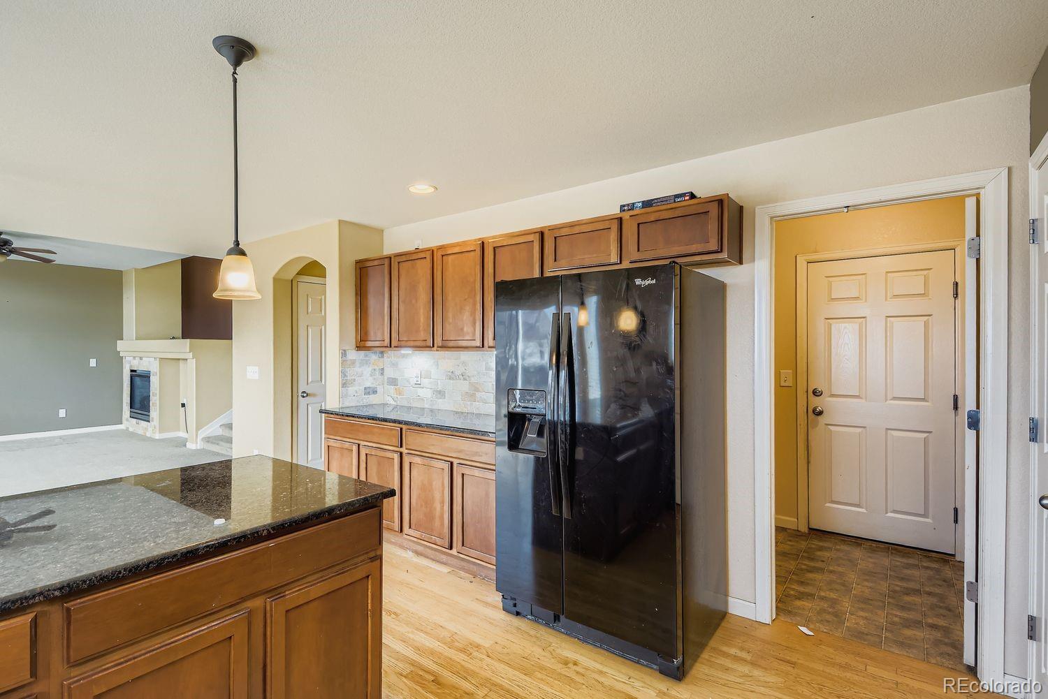 166 Bittern Drive Johnstown, CO 80534 - Photo 11 of 28 a kitchen with stainless steel appliances granite countertop a refrigerator a oven and a sink with wooden floor