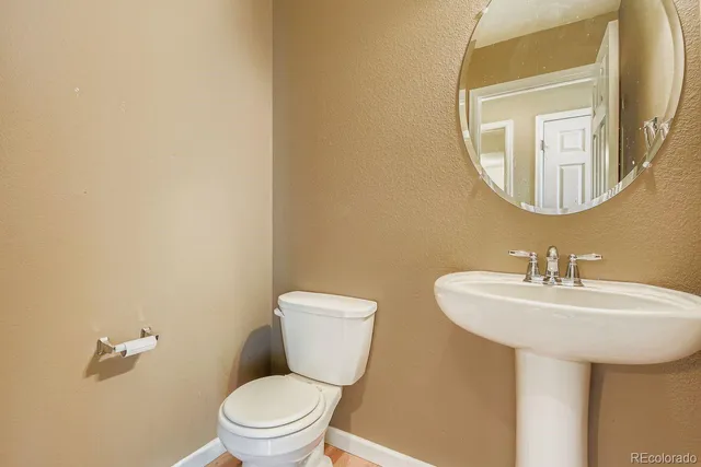 a bathroom with a toilet a sink and a mirror