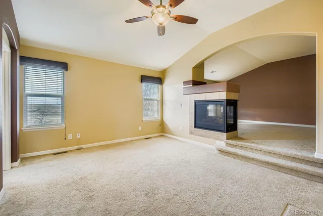 a view of an empty room with a fireplace and a window