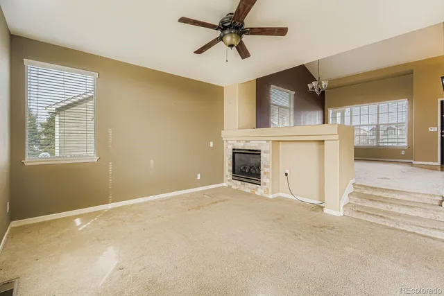 a view of a livingroom with a fireplace and a ceiling fan