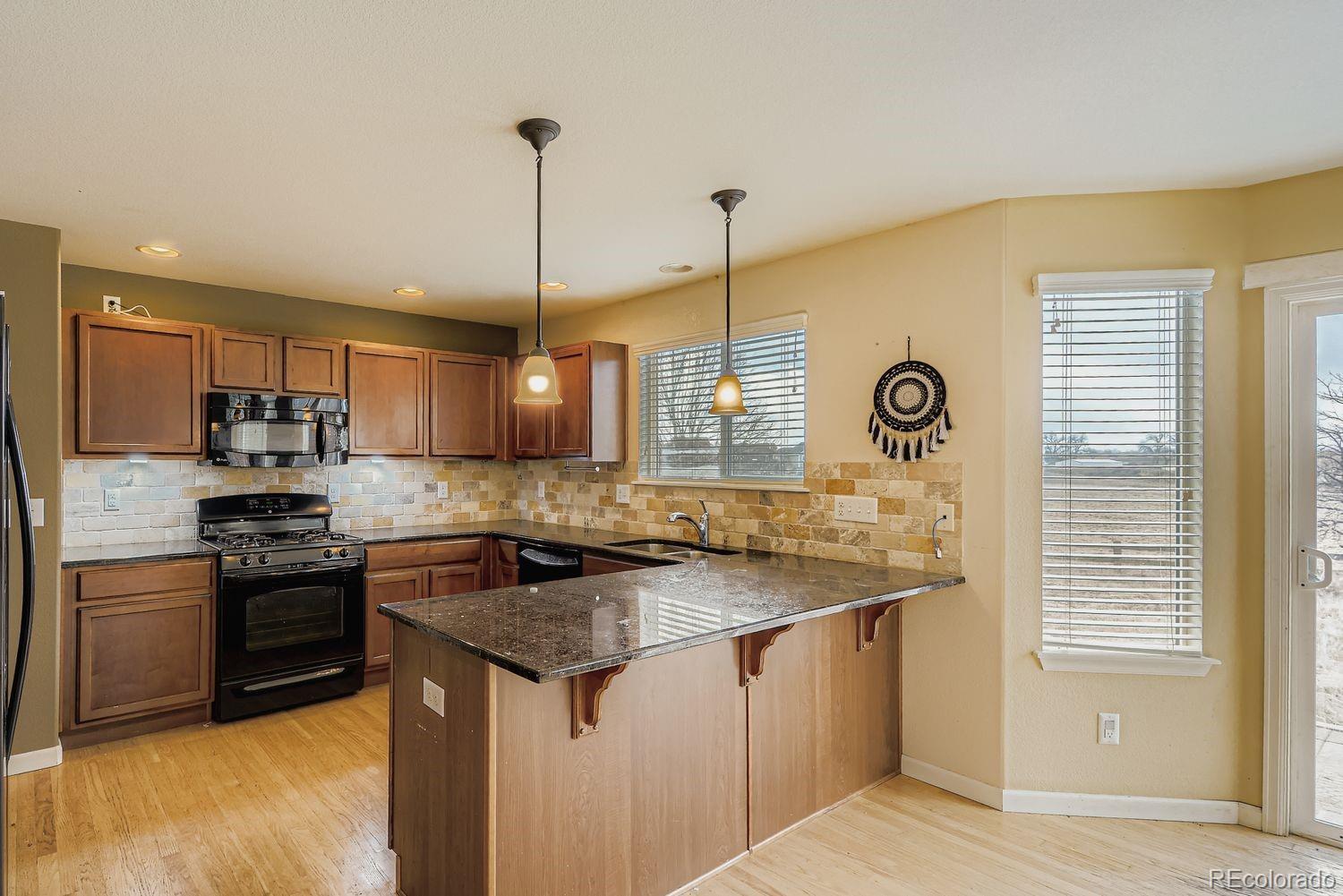 166 Bittern Drive Johnstown, CO 80534 - Photo 8 of 28 a kitchen with stainless steel appliances granite countertop a sink a stove and a refrigerator