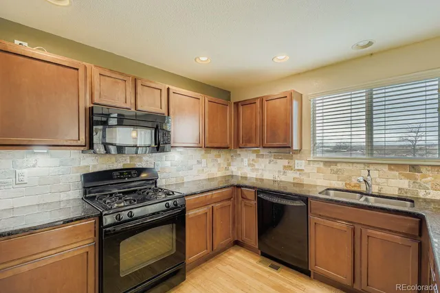a kitchen with stainless steel appliances granite countertop a sink stove and microwave