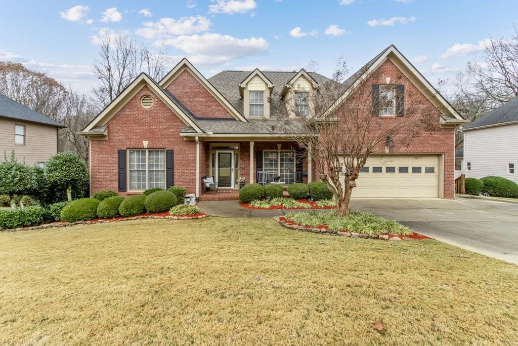 a front view of a house with a yard outdoor seating and garage