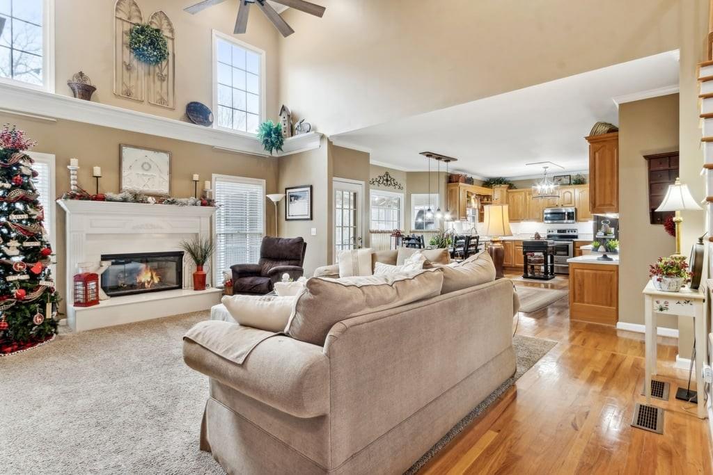 4385 Signal Ridge Court Buford, GA 30518 - Photo 11 of 81 a living room with furniture a fireplace a flat screen tv and a chandelier