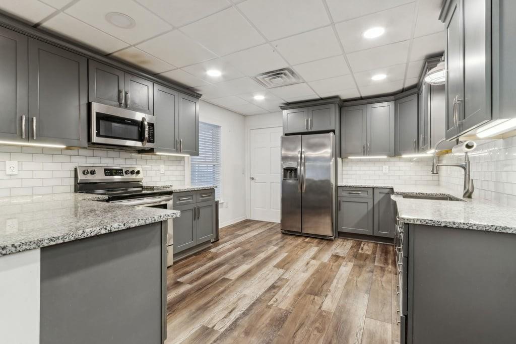 4385 Signal Ridge Court Buford, GA 30518 - Photo 52 of 81 a kitchen with granite countertop a sink stainless steel appliances and cabinets