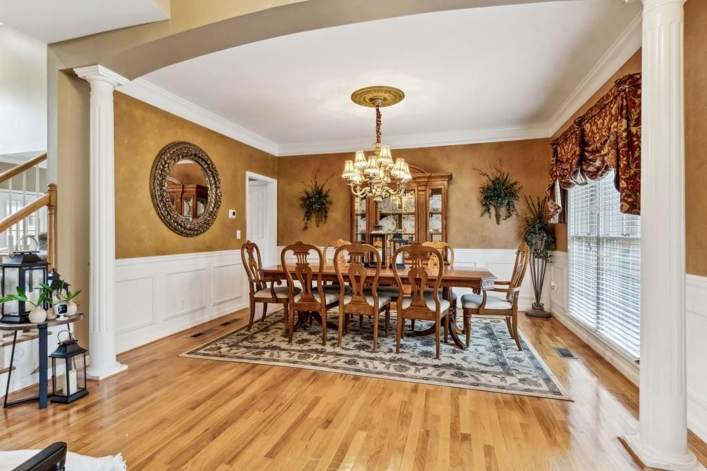 4385 Signal Ridge Court Buford, GA 30518 - Photo 8 of 81 a dining room with furniture a rug and wooden floor