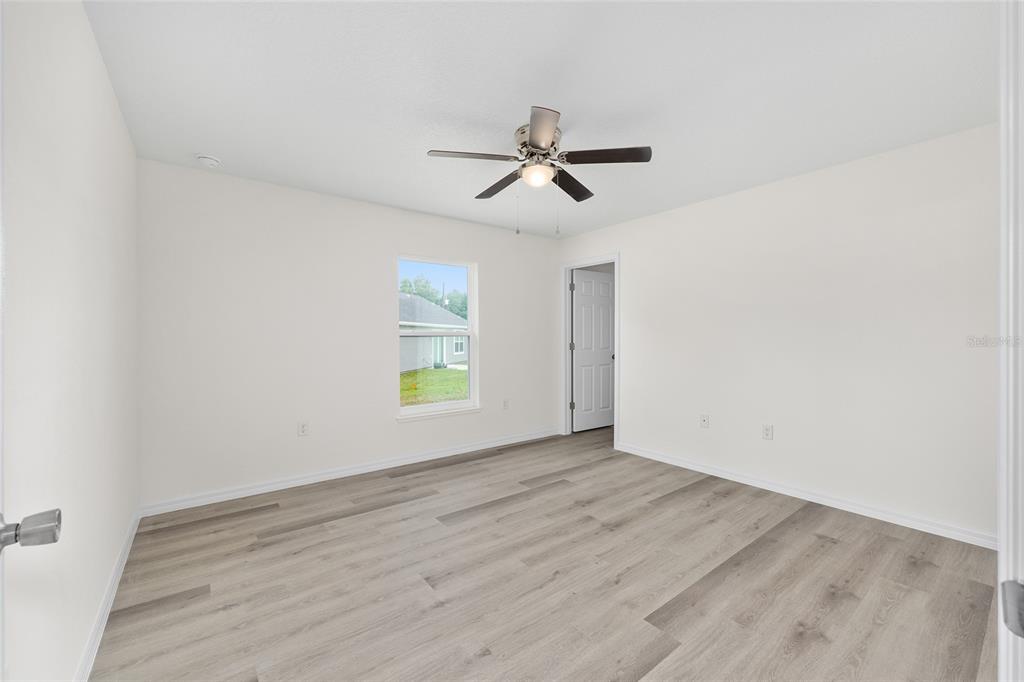 13019 Northeast 7th Loop Silver Springs, FL 34488 - Photo 21 of 35 a view of empty room with wooden floor and fan