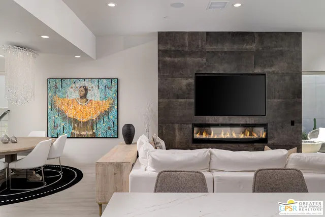 a living room with furniture a flat screen tv and a fireplace