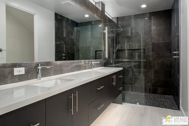 a bathroom with a shower sink and mirror