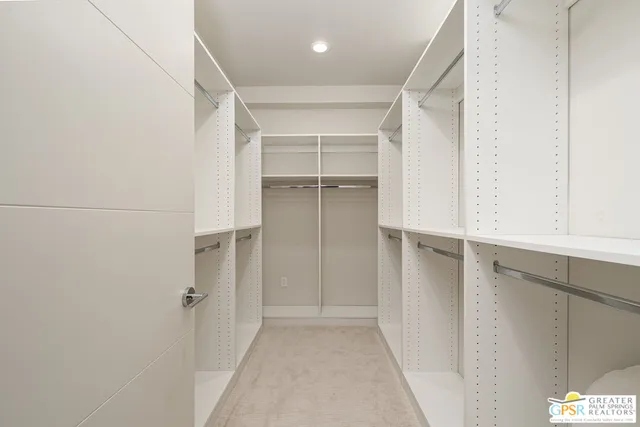 a view of walk in closet with empty racks