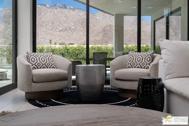 a living room with furniture and a floor to ceiling window