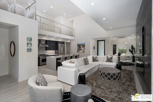 a living room with furniture a table and kitchen view