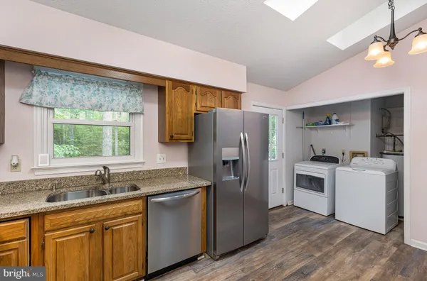 a kitchen with a sink cabinets stainless steel appliances and a window