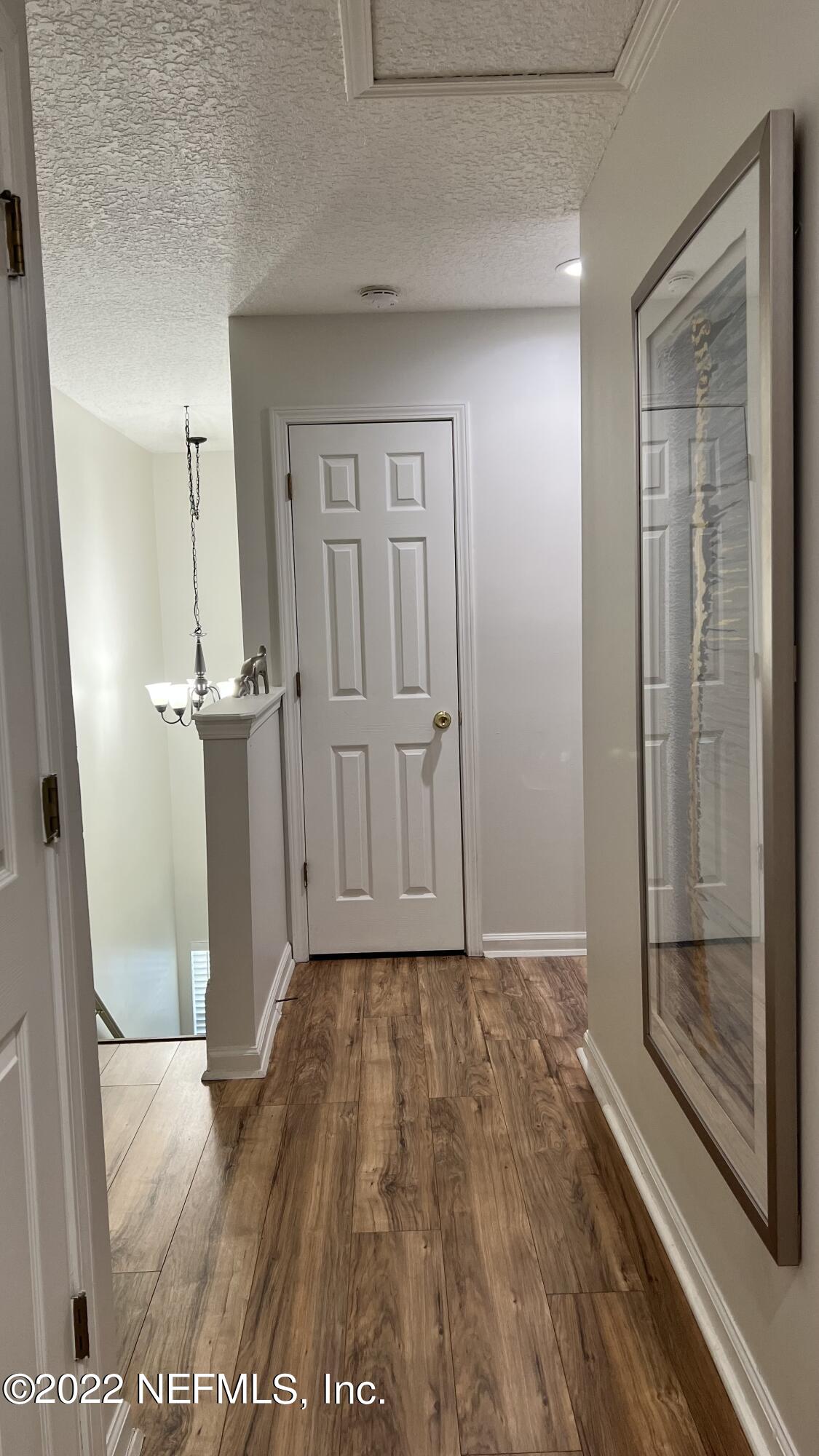 1684 Mayfair Road Jacksonville, FL 32207 - Photo 12 of 34 a view of a hallway with wooden floor and a cabinet