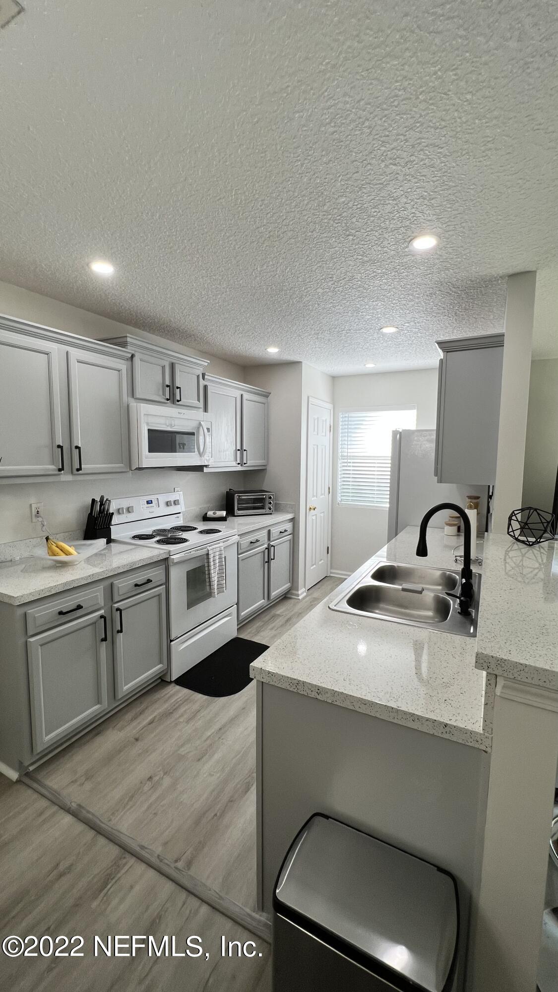 1684 Mayfair Road Jacksonville, FL 32207 - Photo 8 of 34 a kitchen with a sink a stove and cabinets