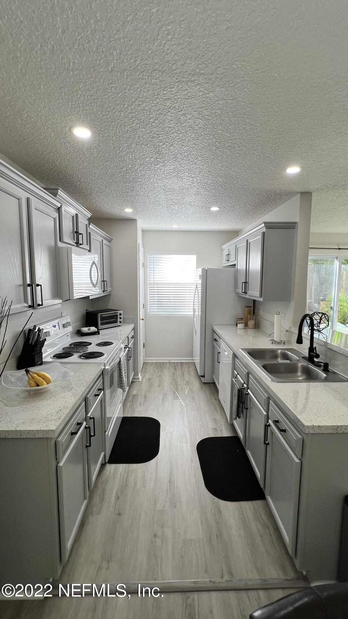 1684 Mayfair Road Jacksonville, FL 32207 - Photo 9 of 34 a kitchen with a sink a stove and cabinets