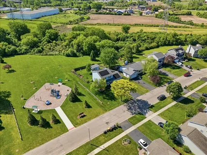 an aerial view of a residential houses with outdoor space and street view