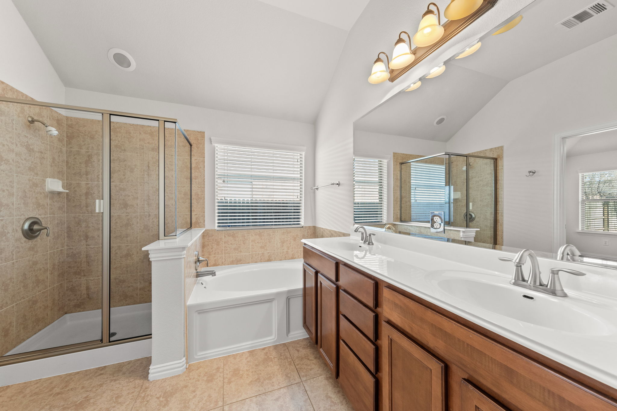 411 Tascate Street Georgetown, TX 78628 - Photo 22 of 41 Indulge in this well-appointed bathroom featuring a double vanity, a glass-enclosed shower, and a soaking tub.