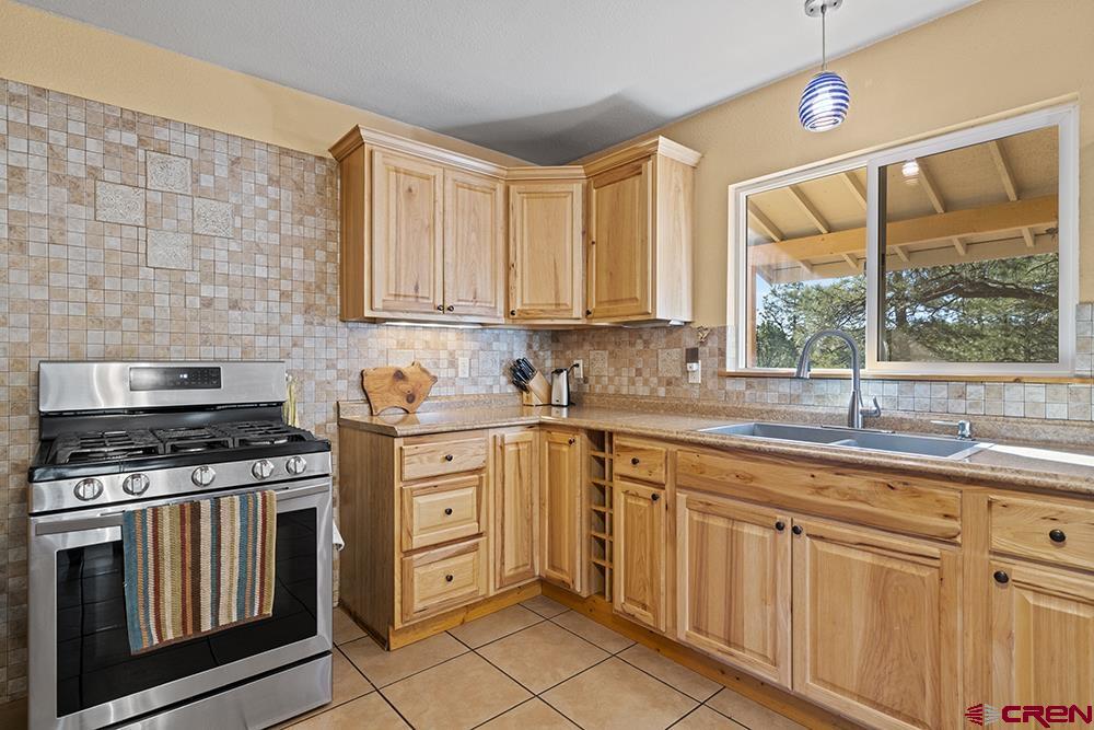 85 Hideaway Road Durango, CO 81303 - Photo 5 of 33 a kitchen with granite countertop a stove sink and cabinets