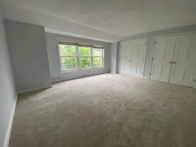 a view of a big room with windows and chandelier fan