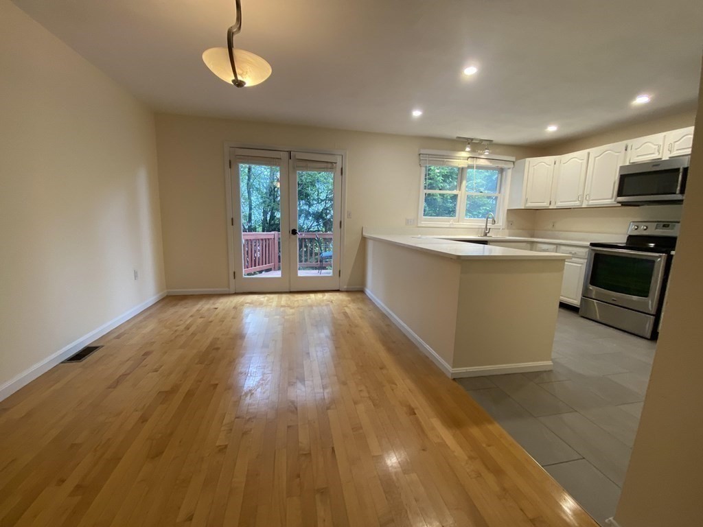 1047 Washington Street, Unit 2 Newton, MA 02465 - Photo 2 of 20 a kitchen with a wooden floor and a window