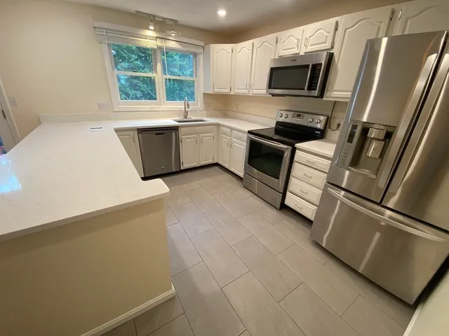 a kitchen with stainless steel appliances a refrigerator sink and microwave