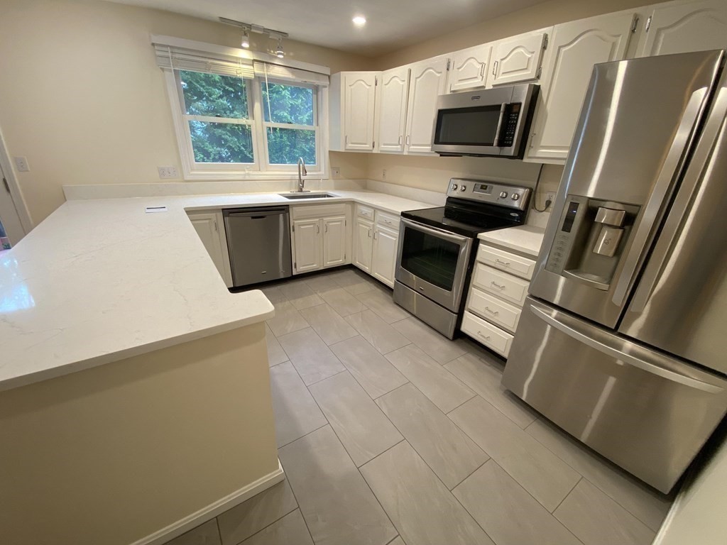 1047 Washington Street, Unit 2 Newton, MA 02465 - Photo 6 of 20 a kitchen with stainless steel appliances a refrigerator sink and microwave
