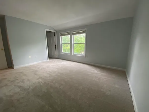 a view of a big room with windows and chandelier fan