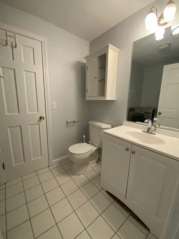 a bathroom with a sink a toilet and a mirror