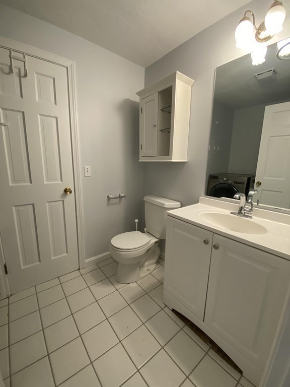 1047 Washington Street, Unit 2 Newton, MA 02465 - Photo 10 of 20 a bathroom with a sink a toilet and a mirror
