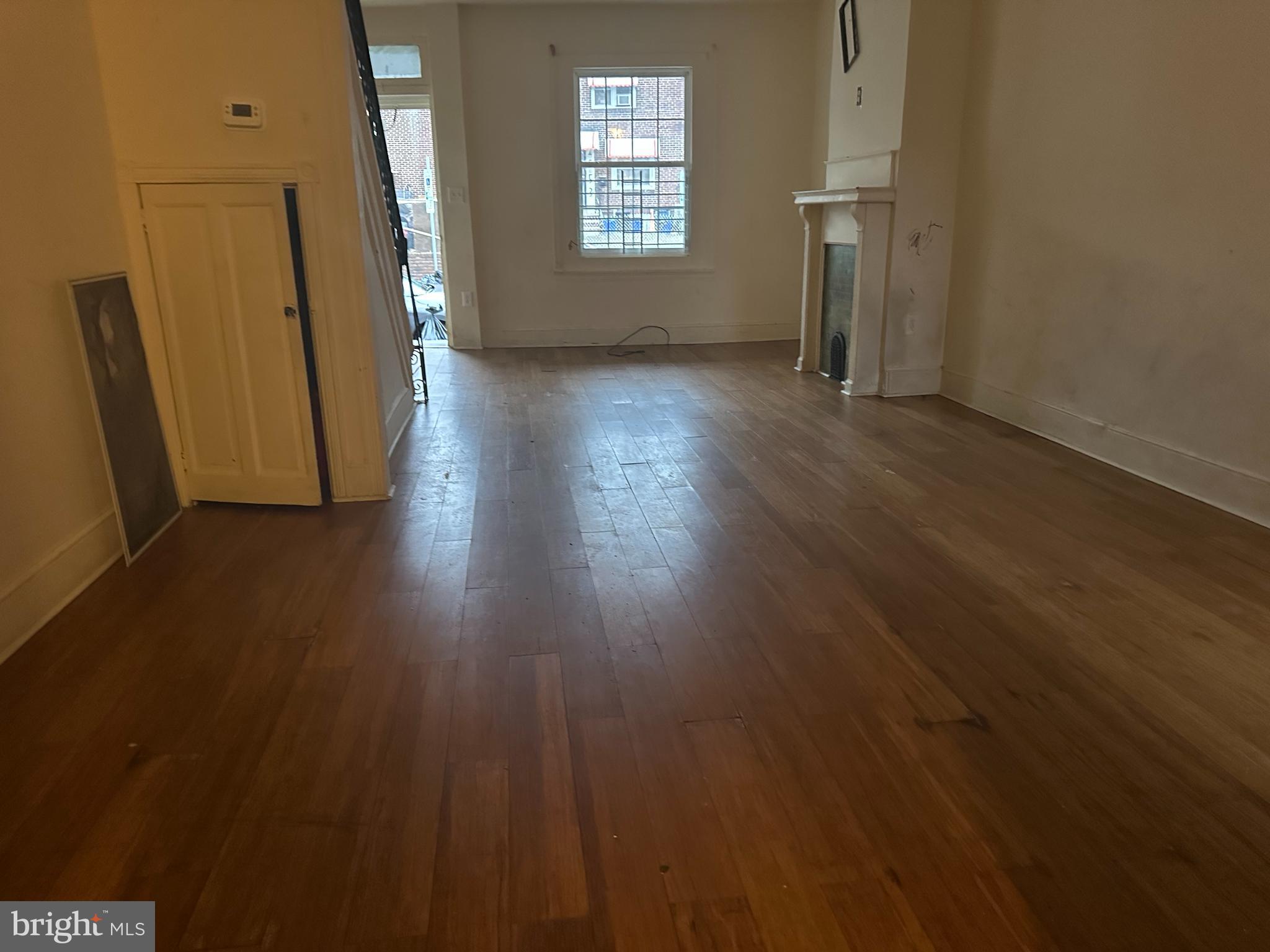 1656 Granite Street Philadelphia, PA 19124 - Photo 2 of 10 an empty room with wooden floor and a window