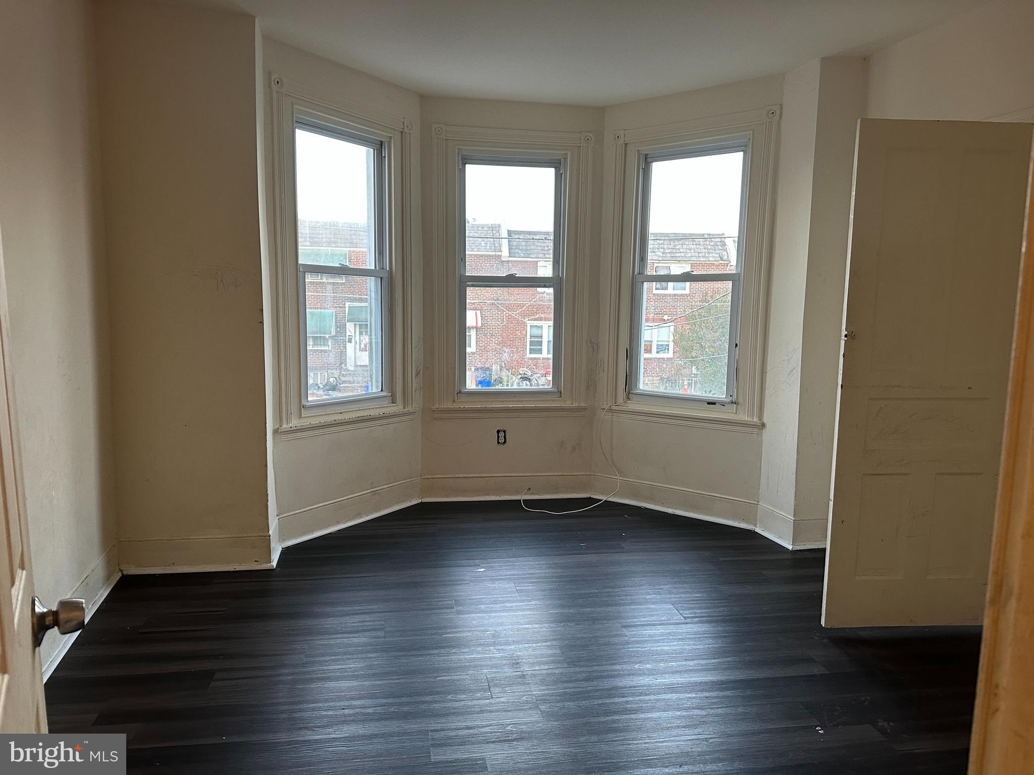 1656 Granite Street Philadelphia, PA 19124 - Photo 7 of 10 an empty room with wooden floor and windows
