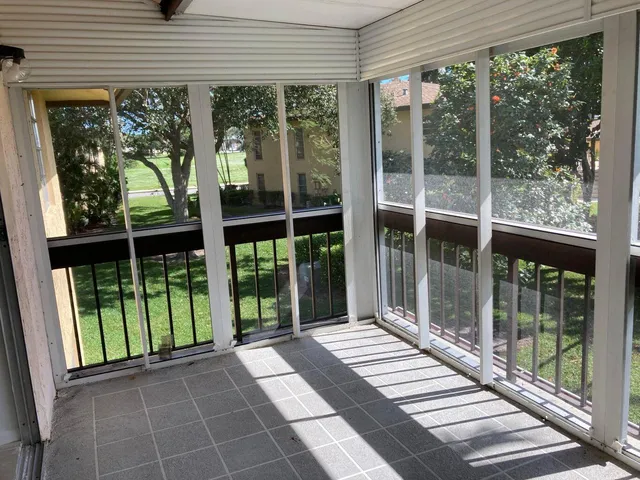 a view of a room with wooden floor and a floor to ceiling window