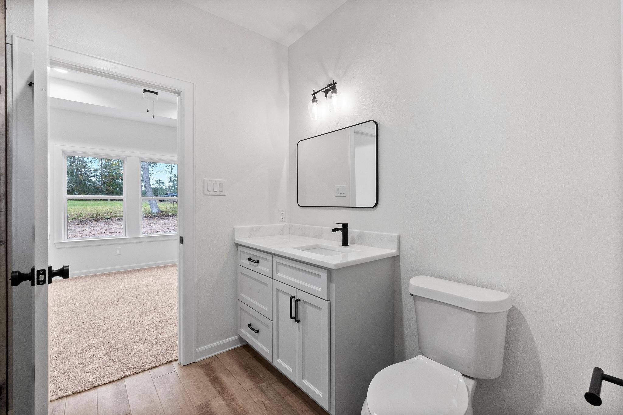 15479 Arrowhead Loop West Willis, TX 77378 - Photo 6 of 7 a bathroom with a toilet a sink and mirror