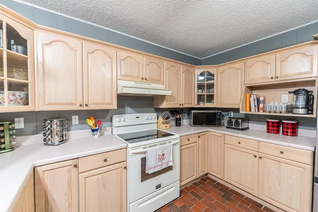 a kitchen with white cabinets and white appliances
